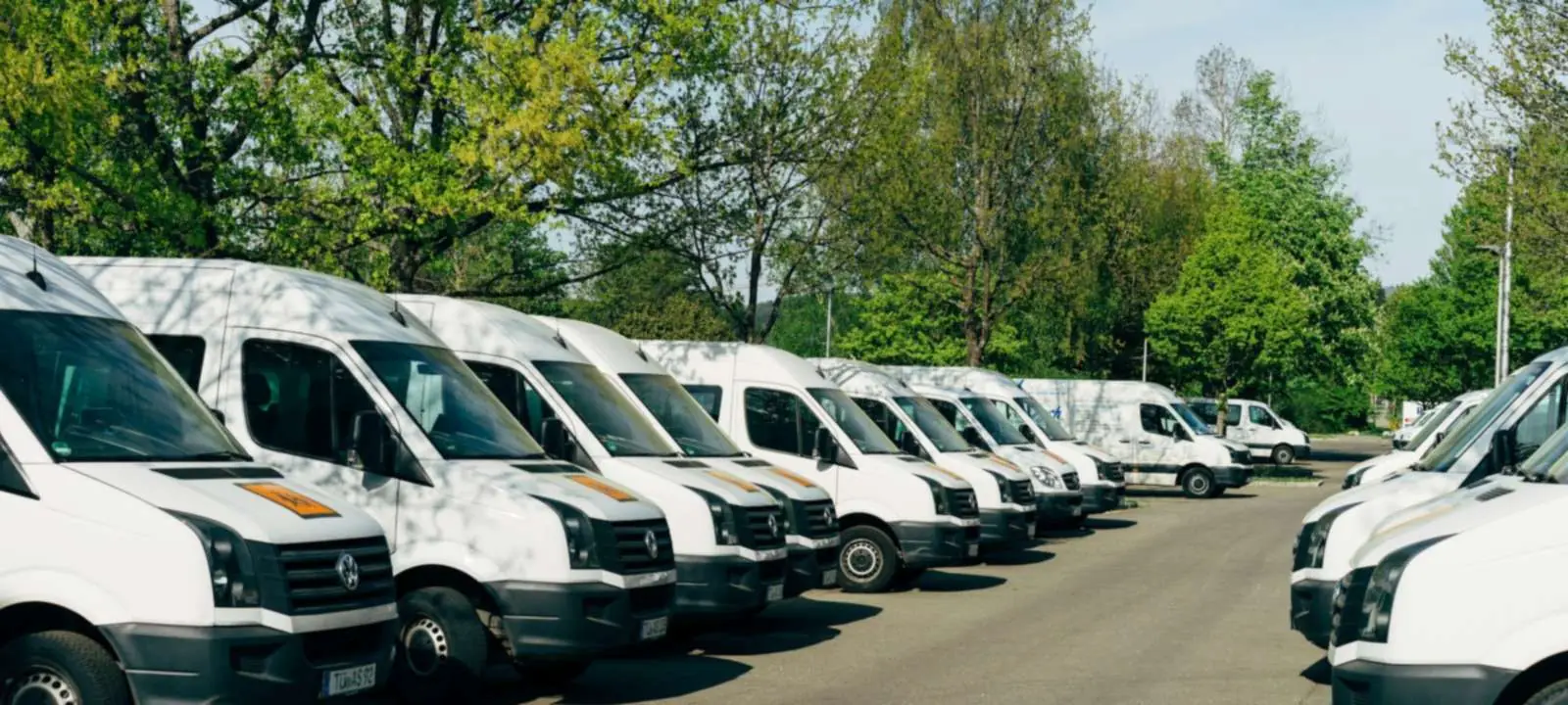 Flota samochodów dostawczych na parkingu firmowym